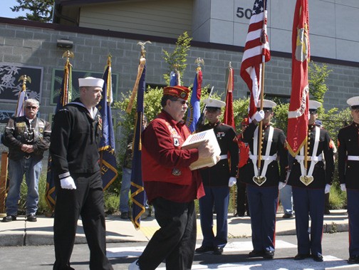 The remains of one of five veterans is carried before a Marine Color Guard Saturday in Bremerton. The remains of the veterans were then transported by an elite escort and hundreds of motorcycles to Tahoma National Cemetery.