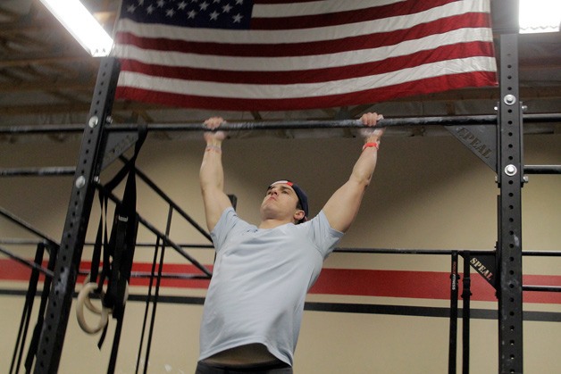 Colby Morse does butterfly pull ups at Agate Pass CrossFit in Poulsbo where he leads classes and guides participants through CrossFit workouts.