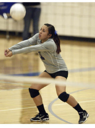 Olympic’s Ashley Pajimula bumps a return in a match against Capital earlier this season. The Lady Trojans play a loser-out match against Kennedy at 10 a.m. today.