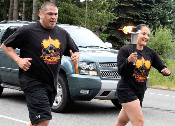 Suquamish Police Sgt. Swift Sanchez and  probation officer Riel Padron carry the Law Enforcement Special Olympics Torch along State Route 305 May 31
