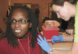 Leanna Weaver receives an inoculation for the H1N1 virus from RN Patrician Johnston