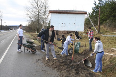 Farron Hakanson (center) and others from the USS John C. Stennis Beach Detachment dig dirt for a roadside culvert along Silverdale Way Tuesday. The project is part of making the area by the Silverdale sign nicer as a new sign is to be placed with the community’s slogan.  A Silverdale slogan contest is underway by the Clear Creek Trail Task Force and the Silverdale Chamber of Commerce.