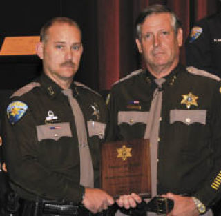 Kitsap County Sheriff Steve Boyer (right) presented Deputy Don Moszkowicz with the Medal of Valor Tuesday. Moszkowicz received the agency’s highest honor for saving a man trapped inside a burning car in March.