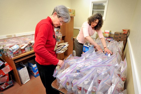 North Kitsap Fishline volunteers Lucy Wells (left) and Katherine Porter assemble bags for Fishline’s Food For Thought program. The bags are delivered to North Kitsap schools on Fridays for students in need to take home for the weekend. Fishline is looking for more volunteers to sort food and make deliveries.