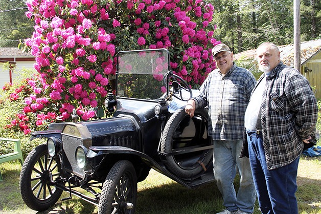 Vern Christopher and Fred Just stand in front of a restored Model-T pickup.
