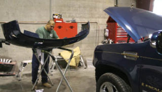 Paul Jimenez works on a Cadillac Escalade’s bumper at Precision Collision Auto Body in Bremerton. The company recently began offering financing options for customers.