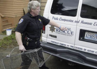 Animal control officer Jody Rosenblad removes a trap that was set in place to catch a stray cat in 2007.