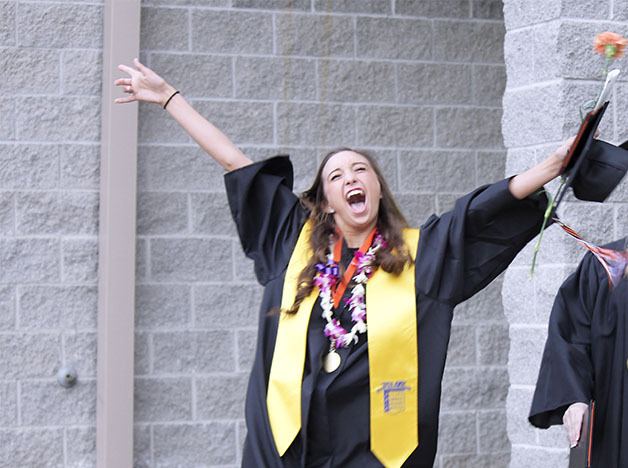 Central Kitsap High School graduate Carly Bergsma throws her hands in the air after commencement.