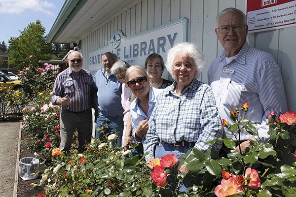 Members of the local rose society pose with their garden at the Silverdale Library.