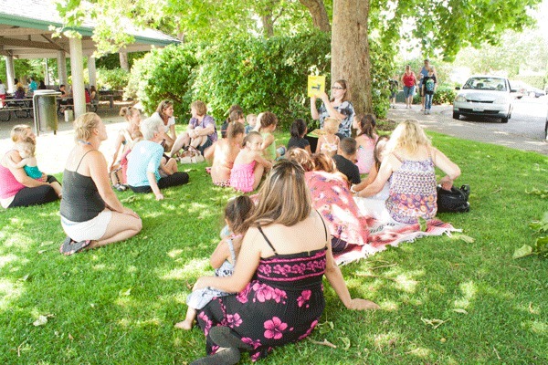 A volunteer reads to a group of children and their parents at the Silverdale Waterfront Park as part of the Read Up program. Children are invited to come every Tuesday at 2 p.m. for the reading session. Attendees receive a free book.