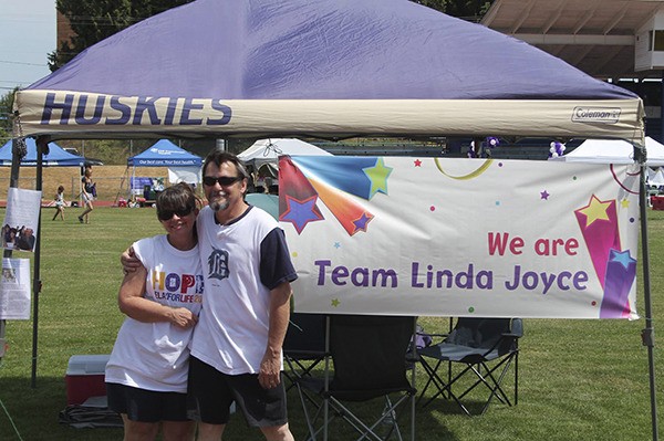 Leslie and Brian Kelly pose in front of their camp site at the Bremerton Relay for Life.