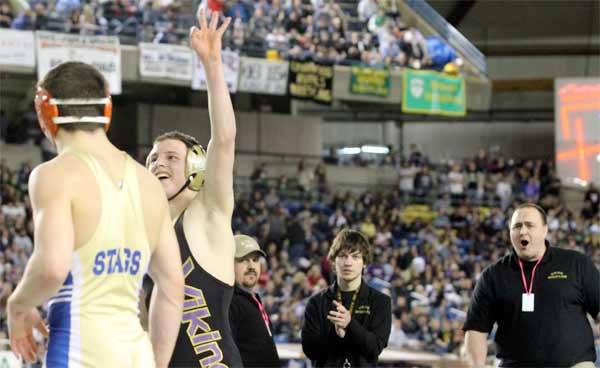 North Kitsap's Jake Velarde holds up three fingers after defeating Joe Grable for the 138-pound 2A State wrestling title. This is Velarde's third State title. On the right