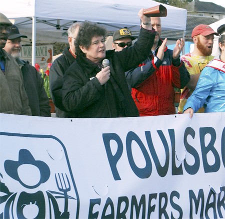 Mayor Becky Erickson rings a cow bell to signal the opening of the Poulsbo Farmers Market for 2013