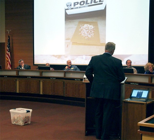 Poulsbo Police Chief Alan Townsend tells the City Council he needs another officer in order to combat drug crimes. On the floor is a box full of syringes.