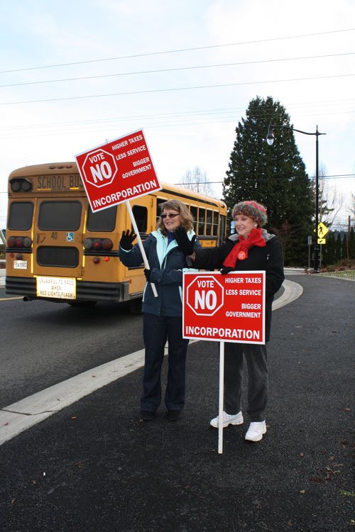 Debbie Davis and Joyce Merkel stand at the round-about at Chico Way and Silverdale Way encouraging voters to vote 'No' on Silverdale annexation Friday afternoon.