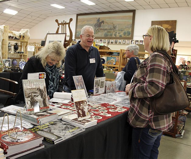 Karolyn 'Zuzu' Grimes autographs a book for a customer at the Kitsap Antique Show on Saturday. Grimes was best known for her role as 'Zuzu' in the movie 'It's a Wonderful Life.' She and Chris Brunell had a booth at the show.