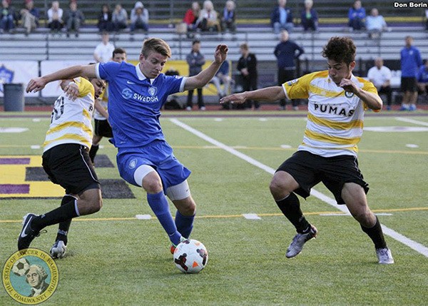 Players for the Kitsap Pumas make defensive plays against  the Puget Sound Gunners.