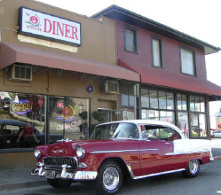 A 1955 Chevy Bel-Air sits in front of the diner. The eatery mirrors the 1950s with its menu