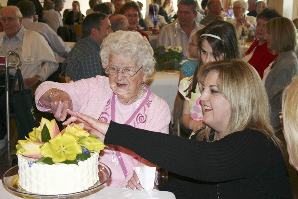 Laura Hagen Westeren cuts her birthday cake at the celebration of her 100th