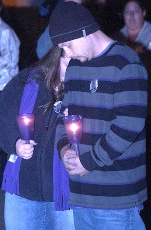 A couple observes a moment of silence during a candlelight vigil for Amber Coplin and her family Nov. 8 at Marina Waterfront Park in Port Orchard.