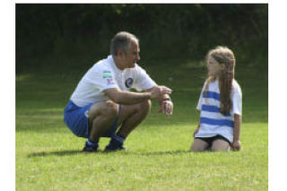 (Above) Kitsap Pumas Executive Director Ben Pecora talks soccer with a young camper at Gordon Field in Tracyton Wednesday. (Right) Pumas forward Tony Kerr mixes soccer with fun at the Pumas youth camp.