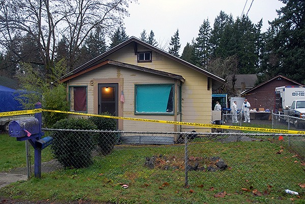 Law enforcement officers walk around a house in the 2000 block of NW Shamrock Drive in Bremerton Dec. 15 during a homicide investigation.