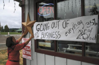 Margie Kluth hangs a star beside A Company of Friends’ “Going out of business” sign. The shop is closing at the end of the month after spending four years in Old Town Silverdale.