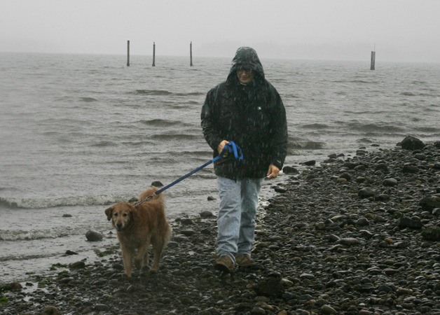 John Toliver and his dog Jake walked along the beach in Silverdale Oct. 14 when the first rain of the season began.