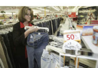 Value Village Manager Kathleen Palmer puts away a pair of jeans in the women’s section. The store