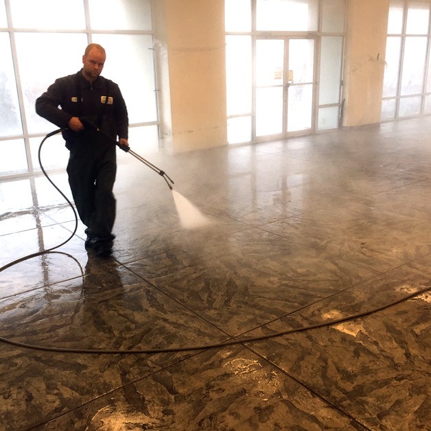 Nick Wall spray washes the new showroom that Hudson Auto Center is moving into as it expands to the former Courtesy Ford dealership on Viking Avenue.