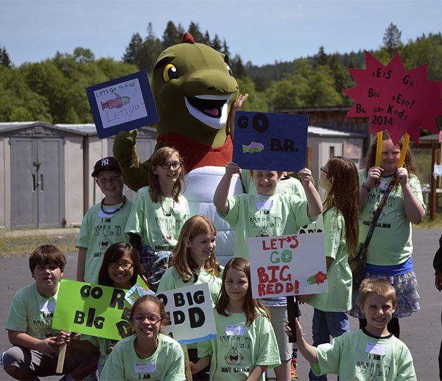 Clear Creek fourth graders pose with Big Redd and hold up signs welcoming him to Kitsap County.