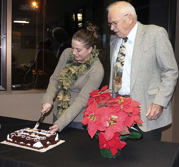 Bremerton Port Commissioner Larry Stokes watches as his granddaughter cuts a celebratory cake at a port meeting Tuesday. He was honored for his recent re-election to a third term on the commission.
