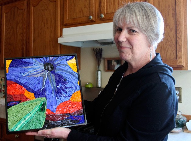 Louise Martin holds mosaic artwork she made with smalti tile. Martin