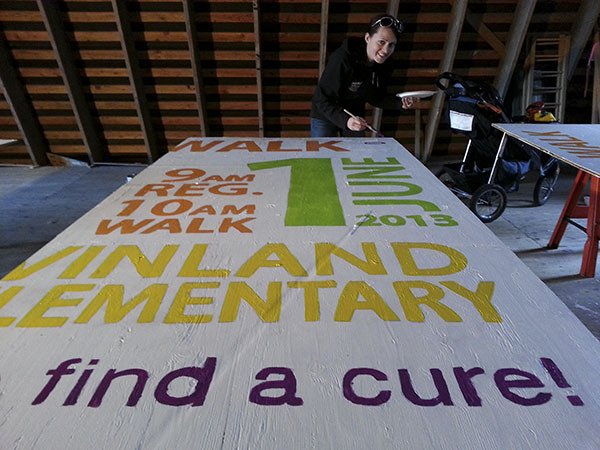 Brianna Strand paints the sign for the Poulsbo CF Walk