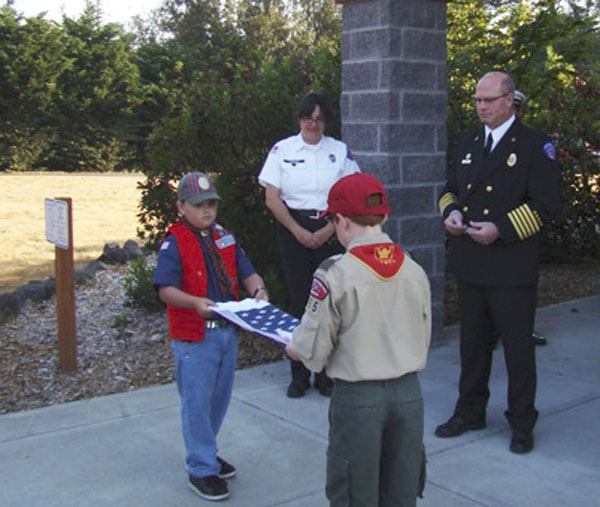 Cub Scout 4555 presents a flag during the 9/11 commemoration at North Kitsap Fire & Rescue’s headquarters station. Below