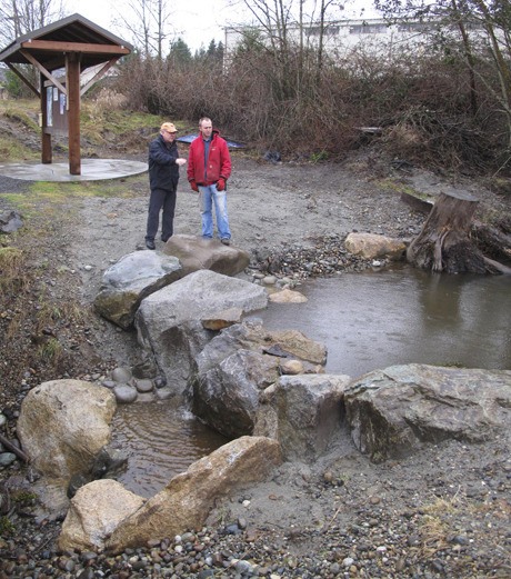 Fish Park volunteers Tom Nordlie (left) and Jonathan Scholten plan finishing touches on the park's new water feature.