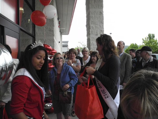 Local festival royalty hand out schwag bags at the grand opening of Silverdale's new liquore box store Beverages and More. Hundreds stood in line Friday Morning before the 9 a.m. opening of the California based liquore retailer.