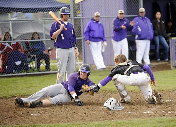 A rare scene: North Kitsap’s Nash Gowin is tagged out at the plate by Sequim catcher Ian Dennis in the fourth inning of an Olympic League matchup on April 23. North Kitsap went on to topple Sequim 10-4.
