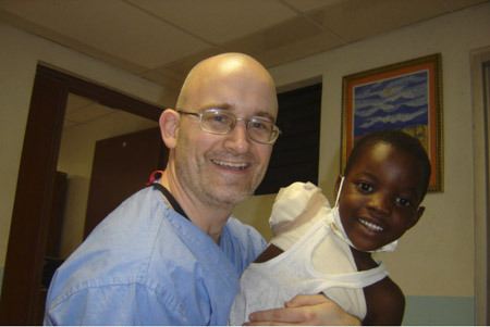 Silverdale surgeon and intensivist Chris Carr holds Haitian earthquake survivor Luciano Josene