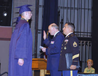 Three Washington Youth Academy graduating cadets are sworn into the Washington National Guard by Maj. Gen. Lowenberg and 1st Sgt. McQuillan as Gov. Chris Gregoire looks on.