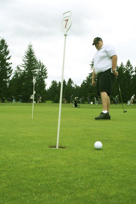 Kyle Spitzer putts at Gold Mountain Golf Course Monday.