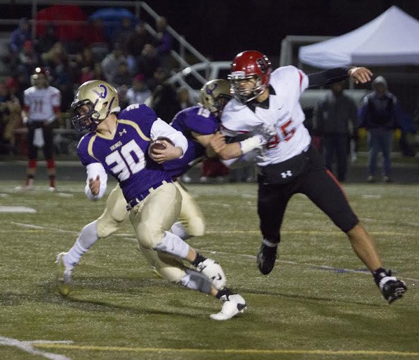 North Kitsap's Carson Bower (30) eludes Archbishop Murphy's Abe Lucas for some yardage early in the quarterfinal game Nov. 21 at North Kitsap. The Vikings held the Wildcats to one score in the first half