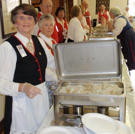 Elaine Lovlie stands with a pan of lutefisk ready to be served at last year’s Sons of Norway Lutefisk and Swedish Meatball Dinner.