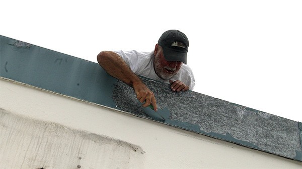 Volunteer Bernie Wittman scrapes away some old paint atop the soon-to-be Poulsbo Maritime Heritage Museum building