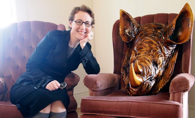 Danya Simkus sits with a wood-carved rhino bust she had commissioned in honor of No. 7 Book's one-year anniversary. The rhino is an homage to author Ernest Hemingway.