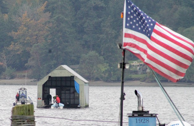 John Zetty anchors his boathouse in Liberty Bay shortly after it broke free of tow lines in heavy winds.