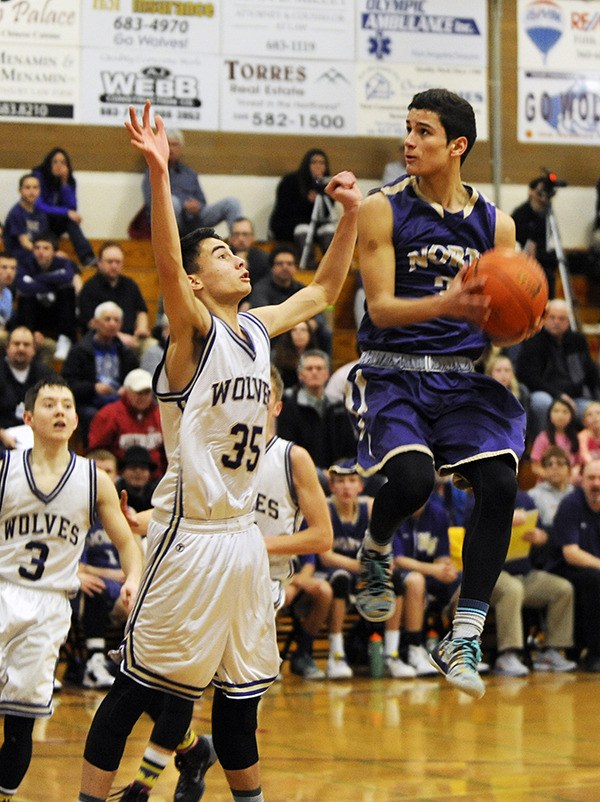 North Kitsap senior guard David Perry drives past Sequim’s Alex Perry for a shot as the Vikings take on Sequim’s Wolves Feb. 3.