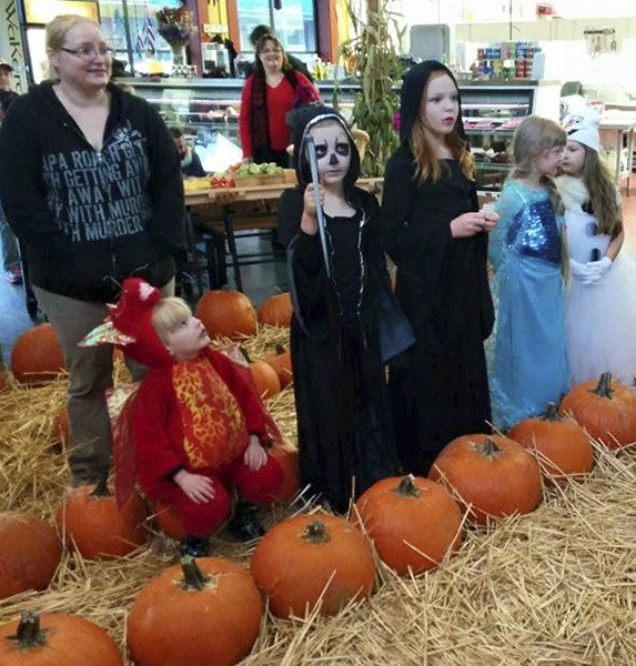 Little ghouls and goblins (and a princess or two) line up behind a string of pumpkins at the Port Orchard Public Market’s Pumpkin Palooza last year.