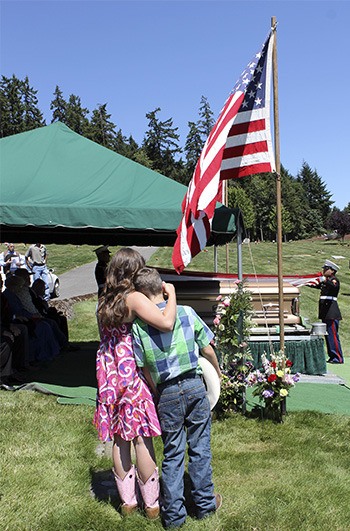 Two children hug at the funeral of relative Nick Corey at Miller-Woodlawn cemetery in Bremerton on Friday morning. Corey was known as a true cowboy to many throughout the county due to his love of ranch work.