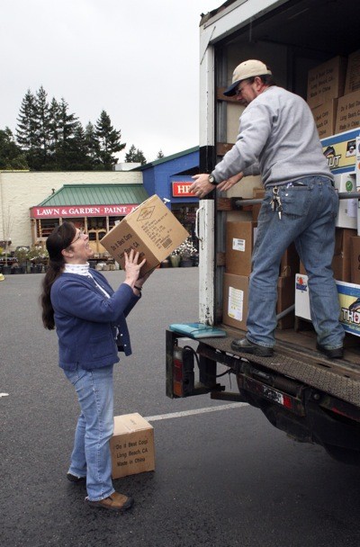 Bev Beasley helps Jim Stuart of Children of the Nations load shelter packages into a truck.